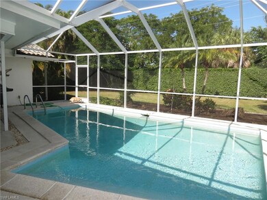 View of pool with screen enclosure and a yard