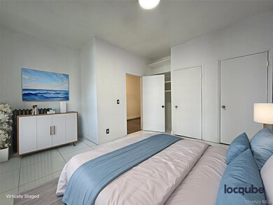 Bedroom featuring light tile patterned floors and two closets