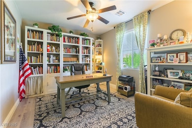 Office area with a ceiling fan and light wood-style floors
