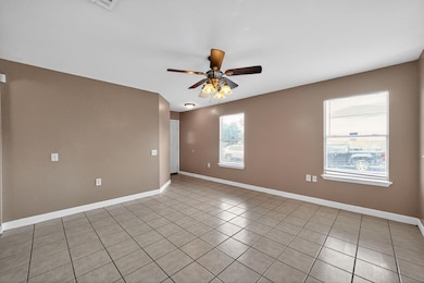 Unfurnished room with ceiling fan and light tile patterned flooring
