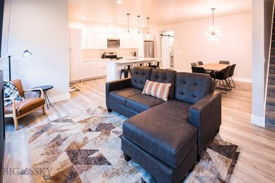 Living room featuring a barn door, light hardwood