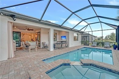 View of swimming pool featuring a sunroom, outdoor dining area, ceiling fan, glass enclosure, and a pool with connected hot tub