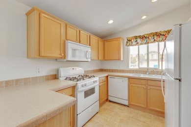 Functional kitchen with white appliances, wrap aro