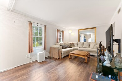 Living area with hardwood / wood-style flooring and ornamental molding