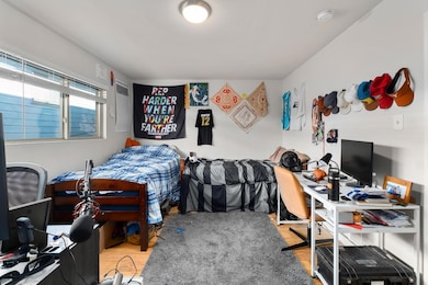 Bedroom with an office area and wood finished floors