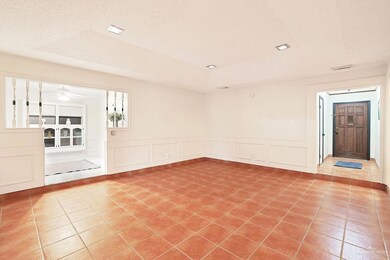 Spare room featuring light tile patterned floors, a decorative wall, a wainscoted wall, and a ceiling fan