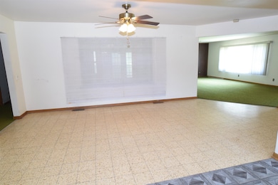 The dining room is also  spacious room.  Plenty of space for a large table or multiple tables if needed.  This space is open to the kitchen & living room.  The window area can be opened to access the unfinished space of the home for an extra Family r