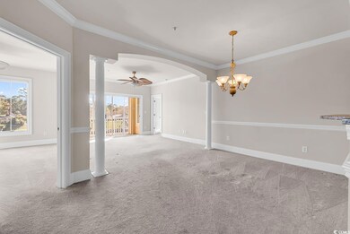 Unfurnished room featuring crown molding, light colored carpet, a ceiling fan, arched walkways, and decorative columns