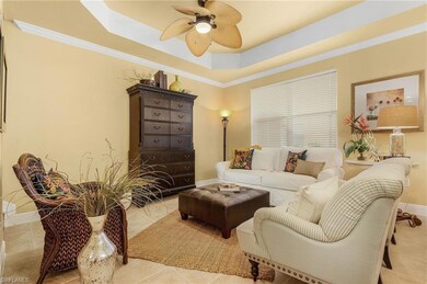 Living area with a ceiling fan, a tray ceiling, ba
