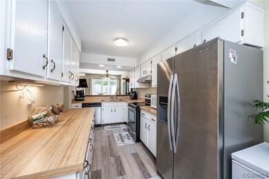 Galley Kitchen with white cabinets, appliances wit