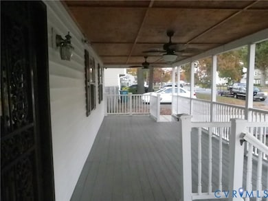 Wooden porch featuring a ceiling fan