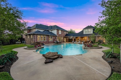 Expansive resort-style pool with 12-foot deep end and natural stone diving rock, surrounded by lush landscaping — the ultimate backyard retreat.