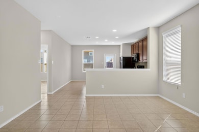 Kitchen with light tile patterned floors, light countertops, a peninsula, recessed lighting, and freestanding refrigerator