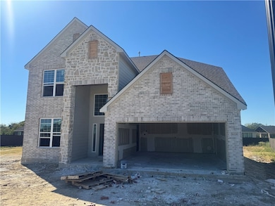 French country home with brick siding and an attached garage