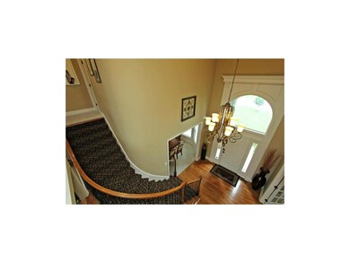 Soaring entry with Curved Staircase and wall