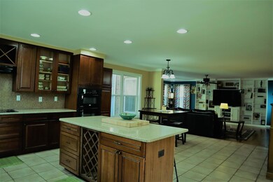 Large island with shelves and a quartz top. Pull up a chair or prepare your final dish!