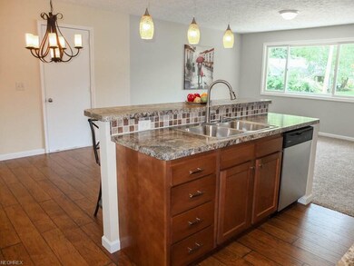 Kitchen has a center island and breakfast bar.