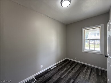 Bedroom with dark wood finished floors and baseboards