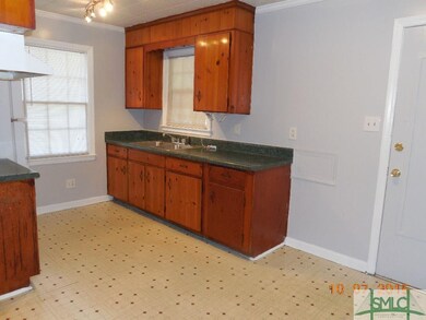 Galley kitchen.  Note original wood cabinets.