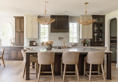 Beautiful gourmet kitchen with quartzite countertops, stunning glass cabinetry, and more!