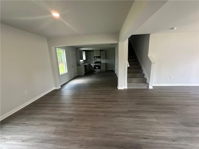 Unfurnished living room featuring stairs, dark wood-style flooring, and recessed lighting