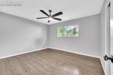 Spare room with wood finished floors and a ceiling fan