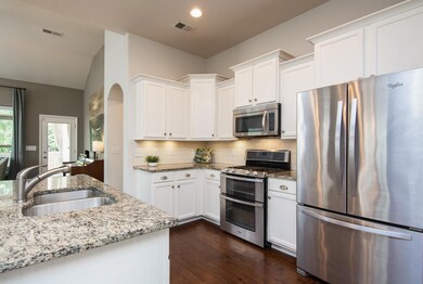 White kitchen, granite, and a gas stove. 