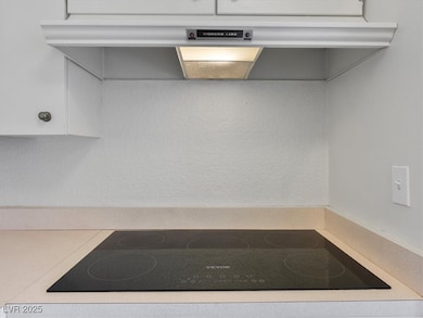 Kitchen view of black electric cooktop, under cabi