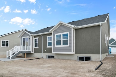 Rear view of house featuring stucco siding and a shingled roof