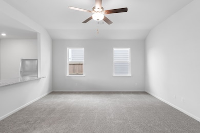 Spare room with carpet, ceiling fan, and lofted ceiling
