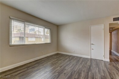 Spare room with a textured ceiling, dark wood-styl