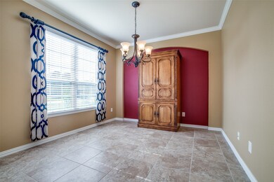 A deep cranberry accent wall makes this room pop alongside the geometric pattern curtains while crown molding tops off the look.