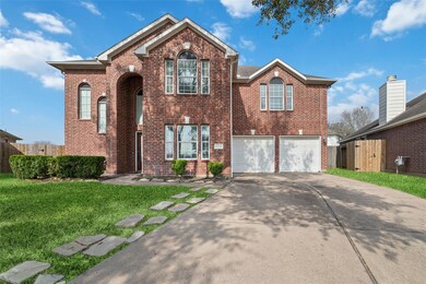 This photo showcases a spacious two-story brick house with a double garage. The home has multiple large windows, providing ample natural light.
