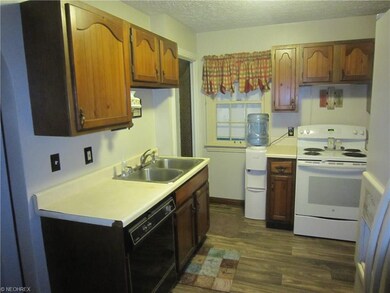 Kitchen with stove, refrigerator and water cooler.