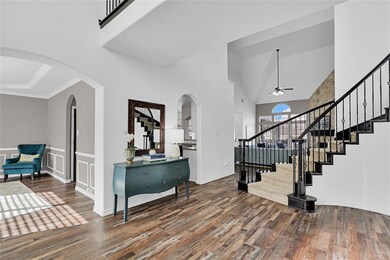 Flanking the foyer is the light and bright formal dining room with graceful aches, decorative lighting and tray ceiling.