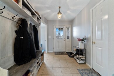 Mudroom with baseboards and light tile patterned f