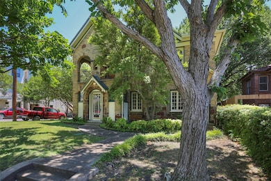 View of front facade with stone siding, a front lawn, and brick siding