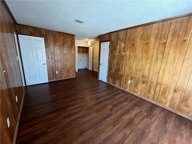 Unfurnished bedroom with a textured ceiling, dark 