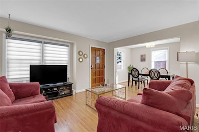 Living room with light wood-style floors and a chandelier