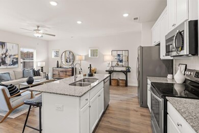 Kitchen featuring stainless steel appliances, ceiling fan, white cabinetry, light wood-style flooring, and recessed lighting