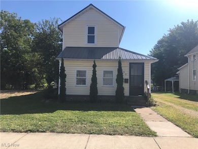 View of front of property with a front lawn and a metal roof