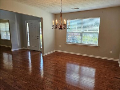 Foyer entrance with a chandelier, a textured ceiling, and dark wood-type flooring