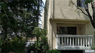 View of front area with balcony & trees on the sid