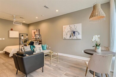 Living area featuring baseboards, light wood fini