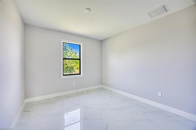 Spare room with light marble finish flooring and baseboards