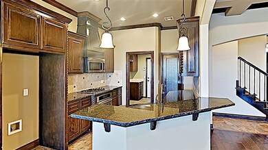 Kitchen with a breakfast bar, recessed lighting, appliances with stainless steel finishes, tasteful backsplash, and dark stone countertops