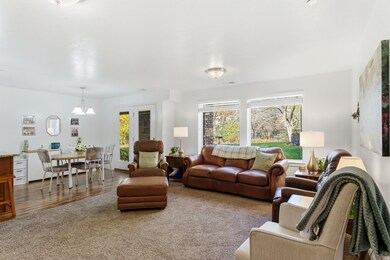 Living area with healthy amount of natural light, wood finished floors, and carpet