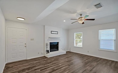 Unfurnished living room with dark wood-style floo