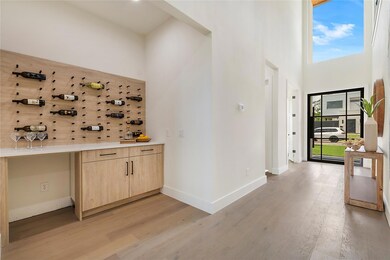 Bar featuring light brown cabinets, wood-type floo