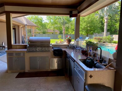 Summer kitchen with DCS grill and dual side burner. Under counter fridge. Nice large sink and lots of storage with stainless cabinet doors. Granite counter tops.